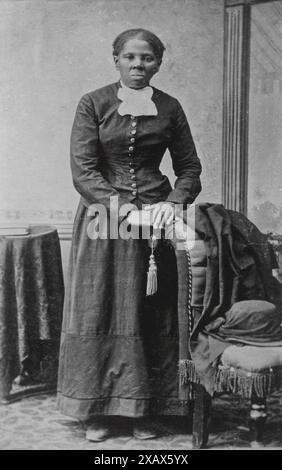 Portrait en noir et blanc d'Harriet Tubman, abolitionniste et chef d'orchestre du chemin de fer clandestin, pris à la fin du XIXe siècle. Elle est formellement habillée et assise avec les mains pliées reposant sur le dos d'une chaise. Banque D'Images