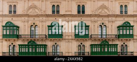 Mur de maison typique à Malte. Briques jaunes calcaires et balcons colorés. Par exemple grreen Banque D'Images