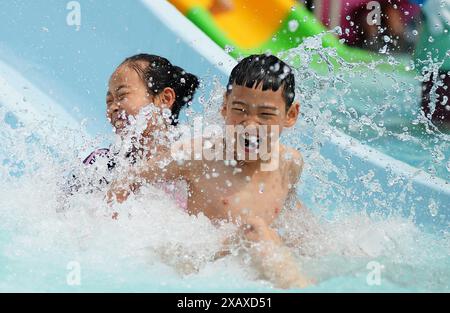 (240609) -- PÉKIN, 9 juin 2024 (Xinhua) -- des enfants jouent dans un parc aquatique à Tengzhou, dans la province du Shandong de l'est de la Chine, 9 juin 2024. Les gens apprécient les vacances de 3 jours du Dragon Boat Festival, également appelé Festival de Duanwu, qui tombe le 10 juin de cette année, via diverses activités à travers le pays. (Photo Li Zhijun/Xinhua) Banque D'Images