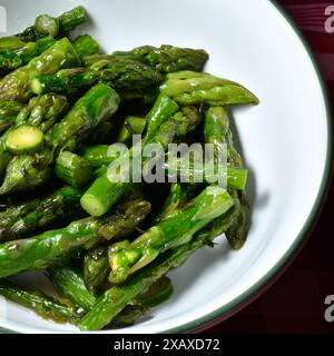 Asperges sautées sur un plat blanc. Banque D'Images
