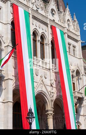 Le bâtiment néo-gothique du parlement hongrois, le Parlement, est décoré de drapeaux aux couleurs nationales hongroises lors d'une fête nationale Banque D'Images