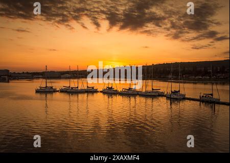 Voiliers amarrés sur un ponton au coucher du soleil, Port de Portsmouth. Banque D'Images