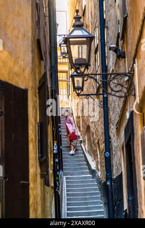 Pose photo d'une jeune femme dans l'allée la plus étroite de Stockholm, Mårten Trotziggränd à Gamla stan. L'architecture du paysage urbain de Stockholm a une influence italienne. Stockholm, Suède Banque D'Images