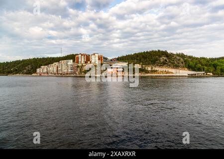 Des immeubles d'habitation neufs à plusieurs étages se dressent sur une pointe rocheuse à Gåshaga au-dessus des eaux de l'archipel de Stockholm. Lidingö kommun, Stockholm, Suède. Banque D'Images