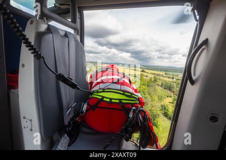 Sauvetage dans des terrains difficiles d'accès. Paramédical du service médical d'urgence d'hélicoptère regardant vers le bas de la porte ouverte de l'hélicoptère Banque D'Images