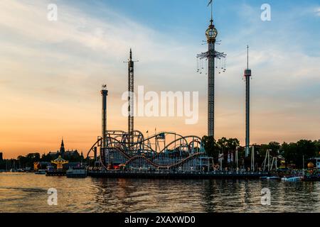 Gröna Lund sur l'île de Djurgården est le plus ancien parc d'attractions de Suède et est également connu sous le nom de Tivoli. Les manèges sont proches les uns des autres. Dans la lumière du soir, les principales attractions telles que le dépliant suédois Eclipse, qui à 121 mètres est l'un des plus hauts carrousels en chaîne d'Europe, se démarquent. Gröna Lund Tivoli. Parc d'attractions saisonnier avec montagnes russes et manèges à sensations fortes, jeux compétitifs et concerts live. Djurgårdsstaden, Stockholm, Suède Banque D'Images