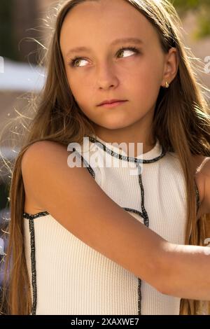 C'est un portrait enchanteur d'une belle jeune fille. Elle a de longs cheveux blonds fluides et des yeux verts fascinants. Banque D'Images