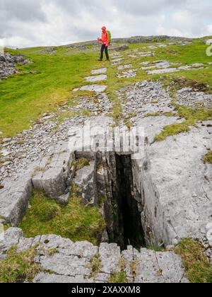 Walker près de l'entrée de la grotte sur Carreg Yr Ogof sur la montagne Noire dans le Brecon Beacons Bannau Brycheiniog National Park Soutn Wales Banque D'Images