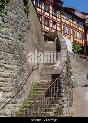 Escalier en pierre mène entre de vieilles maisons à colombages et un mur de pierre au soleil, Meersburg, Allemagne Banque D'Images