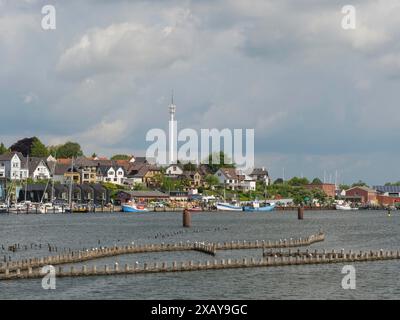 Une vue sur la ville avec une tour de télévision, des bâtiments et des bateaux sur le front de mer sous un ciel partiellement nuageux, Kappeln, Schleswig-Holstein, Allemagne Banque D'Images