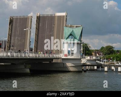 Un pont ouvert à côté d'une petite tour de guet sur une rivière sous un ciel nuageux dans une ville, Kappeln, Schleswig-Holstein, Allemagne Banque D'Images