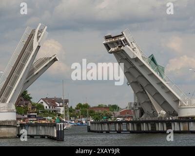 Pont basculant sur le port en état ouvert, avec des bateaux et des bâtiments le long de la rive sous un ciel nuageux, Kappeln, Schleswig-Holstein, Allemagne Banque D'Images