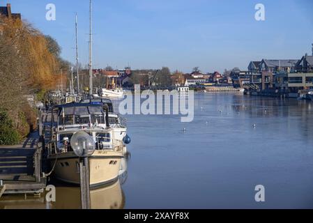 Bateaux couchés tranquillement dans le port dans l'eau claire, entouré d'arbres et de mouettes sous un ciel d'été, Leer, Frise orientale, Allemagne Banque D'Images