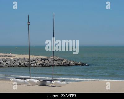 Trois bateaux sur la plage de sable à côté des brise-lames avec mer calme en arrière-plan, ostende, Belgique Banque D'Images