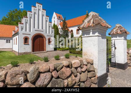 Lindelse Kirke, église typique danoise de 1830, blanchi à la chaux, toit de tuiles rouges, colline, porte d'entrée, pignon à gradins, mur en pierre naturelle, Rudkobing Banque D'Images