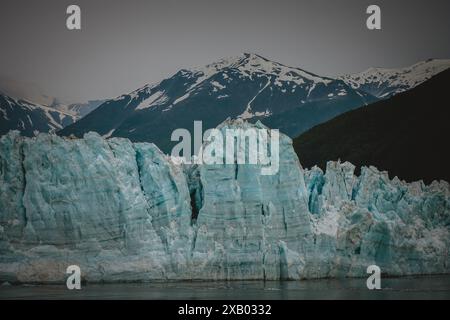 Admirez la beauté brute des glaciers de l'Alaska avec cette superbe image montrant des formations de glace déchiquetées contre des montagnes enneigées. Parfait pour natur Banque D'Images