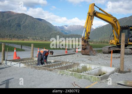 Un constructeur travaille à la construction d'un arrêt pour bétail dans une ferme laitière dans la vallée Haupiri, côte ouest, Nouvelle-Zélande Banque D'Images