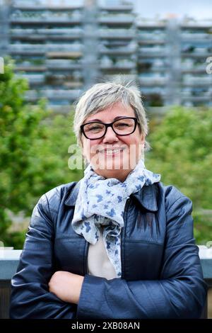 Portrait de femme âgée caucasienne mature heureuse regardant souriante debout avec les bras croisés à l'extérieur. Banque D'Images