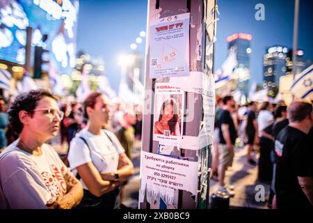 Tel Aviv, Israël. 08 juin 2024. Les manifestants se tiennent à côté d'une petite image d'Eden Yerushalmi qui est prise en otage par le Hamas à Gaza lors d'une manifestation. Des milliers de manifestants se sont rassemblés dans différents endroits à travers Israël samedi soir pour appeler à un accord d'otages et à de nouvelles élections quelques heures seulement après la nouvelle du sauvetage des quatre otages C Noa Argamani, Almog Meir Jan, Andrey Kozlov et Shlomi Ziv C. (Photo par Eyal Warshavsky/SOPA images/SIPA USA) crédit : SIPA USA/Alamy Live News Banque D'Images