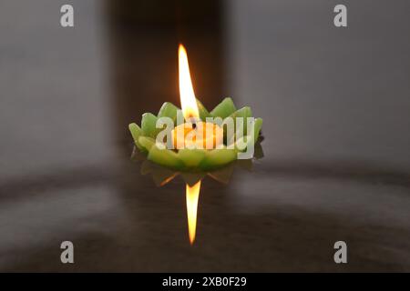 Bougies de Krathong avec des flammes flottant sur l'eau, Un rituel bouddhiste qui est censé enlever les mauvaises choses de la vie quand les bougies flottent. Banque D'Images