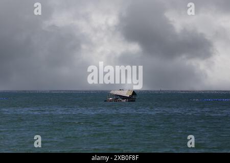 radeau flottant de pêcheur au milieu de la mer un jour de pluie et une tempête à venir. Banque D'Images