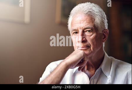 Pensée, dépression et portrait de l'homme âgé dans le salon à la maison pour se souvenir de la mémoire ou le reflet de l'histoire passée. Triste, visage et personne avec Banque D'Images