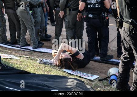 Israël. 08 juin 2024. Des policiers israéliens poussent au sol une manifestante arabe israélienne contre la guerre. Des militants israéliens arabes et juifs pour la paix se sont rassemblés pour une manifestation conjointe contre la guerre Israël-Hamas à Gaza, demandant un cessez-le-feu et un accord sur les otages le jour de l'opération de sauvetage des otages de Tsahal à Nuseirat. Tel Aviv, Israël. 08 juin 2024. (Matan Golan/Sipa USA). Crédit : Sipa USA/Alamy Live News Banque D'Images