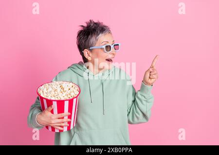 Photo de positive funky Lady habillée kaki sweat-shirt profiter du film pop corn montrant l'espace vide isolé de fond de couleur rose Banque D'Images