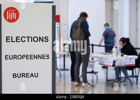 Lille. 9 juin 2024. Les gens votent dans un bureau de vote pour les élections du Parlement européen à Lille, dans le nord de la France, le 9 juin 2024. Le Parti du rassemblement national d'extrême droite français a reçu 32% des voix aux élections du Parlement européen de 2024 en France, réalisant des gains considérables par rapport aux élections précédentes, selon une retransmission en direct du média local BFMTV dimanche. Crédit : Sebastien Courdji/Xinhua/Alamy Live News Banque D'Images