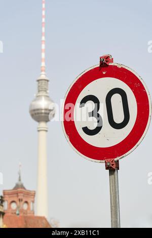 Panneau de signalisation avec la limite de vitesse de 30 km/h à Berlin avec la tour de télévision en arrière-plan Banque D'Images