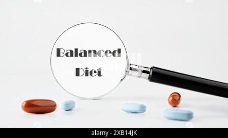 Alimentation équilibrée. Texte de régime équilibré écrit à travers une loupe sur un fond clair. Photo conceptuelle Banque D'Images