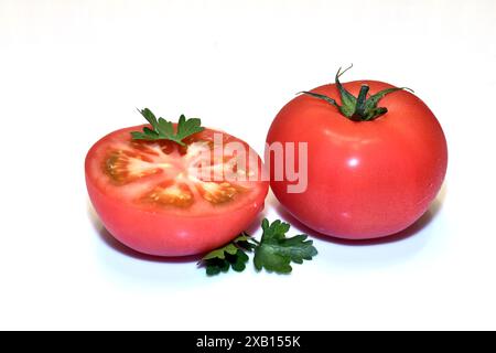 Deux tomates rouges mûres, une entière, l'autre coupée en deux. Banque D'Images