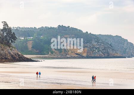 Côte rocheuse avec des gens marchant sur la plage Banque D'Images