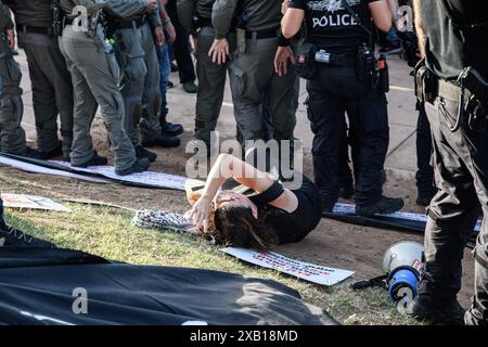 Tel Aviv, Israël. 08 juin 2024. Des policiers israéliens poussent au sol une manifestante arabe israélienne pendant la manifestation. Des militants israéliens arabes et juifs pour la paix se sont rassemblés pour une manifestation conjointe contre la guerre Israël-Hamas à Gaza, demandant un cessez-le-feu et un accord d'otages le jour de l'opération de sauvetage des otages de Tsahal à Nuseirat. Crédit : SOPA images Limited/Alamy Live News Banque D'Images
