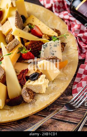 Assiette de fromage préparée avec des fromages de luxe et du vin sur une table en bois Banque D'Images