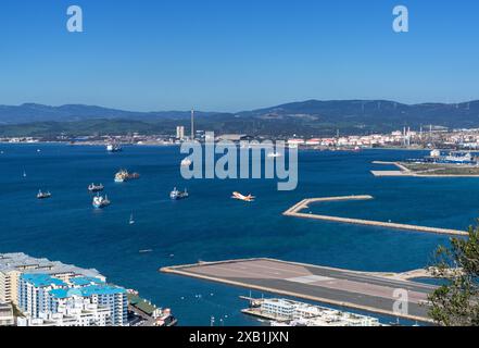 Gibraltar, Royaume-Uni - 27 avril 2024 : un avion décolle de l'aéroport de Gibraltar avec Algeciras Bay derrière Banque D'Images