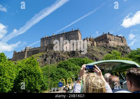 Groupe de touristes appréciant la visite en bus à toit ouvert d'Édimbourg, en passant par le château d'Édimbourg Banque D'Images