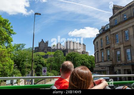 Groupe de touristes appréciant la visite en bus à toit ouvert d'Édimbourg, en passant par le château d'Édimbourg Banque D'Images