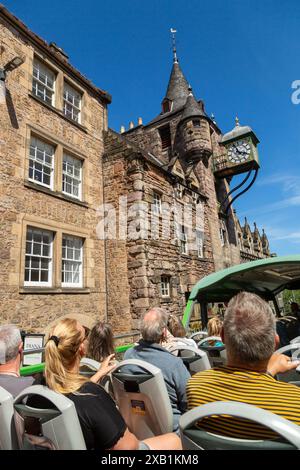 Groupe de touristes appréciant la visite en bus à toit ouvert d'Édimbourg, en passant par Canongate Tolbooth Banque D'Images