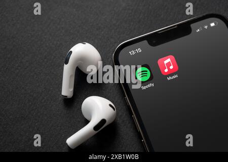 Antalya, Turquie - 5 juin 2024 : icônes Spotify et Apple Music de l'application mobile sur l'écran de l'iPhone avec Airpods à côté Banque D'Images