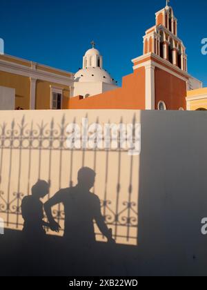 Ombres des touristes comme ils marchent / photographient à Fira, Santorin, Grèce Banque D'Images