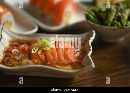 Saumon mariné en sauce shoyu ou sauce soja avec Chili et ail dans une assiette en céramique. Cuisine asiatique Banque D'Images