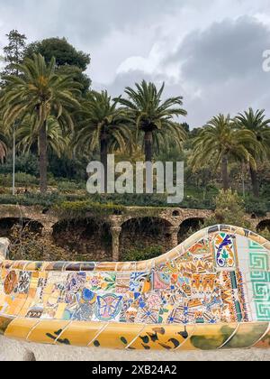 Banc en mosaïque dans le parc Guell de Gaudi à Barcelone, Espagne par jour nuageux. Banque D'Images