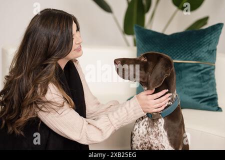 Femmes regardant dans les yeux et touchant le pointeur allemand à poil court Banque D'Images