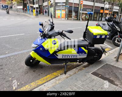 Barcelone, Espagne - 8 juin 2024 : une moto de police de la Guardia Urbana de Barcelona est garée dans une rue de Barcelone. La moto est brillamment c Banque D'Images