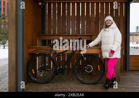 Femme debout à côté de vélo dans la zone couverte Banque D'Images