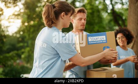 Groupe positif de volontaires préparant l'aide humanitaire et les dons, chargeant des boîtes dans un fourgon cargo. Les travailleurs caritatifs aident les membres de la communauté. Repas gratuits pour les chômeurs, les réfugiés et les immigrants. Banque D'Images