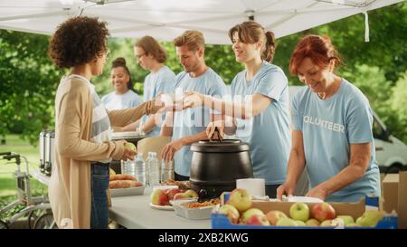 Groupe de volontaires préparant des rations alimentaires gratuites pour les pauvres dans le besoin. Les travailleurs caritatifs et les membres de la Communauté travaillent ensemble. Concept de don, d'aide humanitaire et de société. Banque D'Images