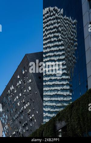 Cette image capture l'architecture moderne frappante de Tbilissi, avec des bâtiments aux motifs géométriques uniques et des façades en verre réfléchissantes sous-jacentes Banque D'Images