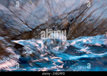 Une image captivante mettant en valeur des motifs tourbillonnants et des reflets vifs dans un corps d'eau de mer, représenté dans des nuances de bleu fascinantes le mouvement fluide Banque D'Images